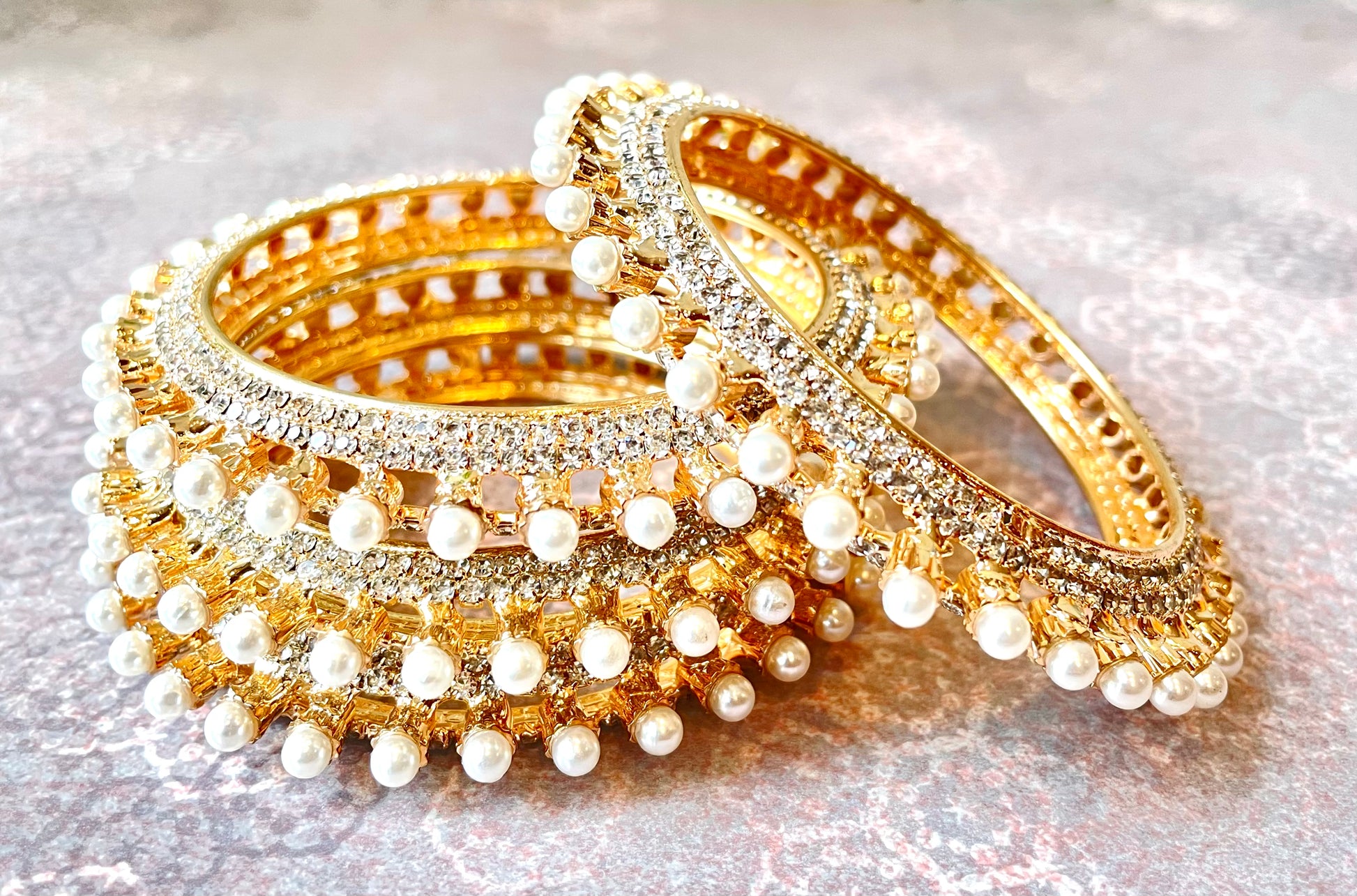 Gold and pearl bangles on a light background